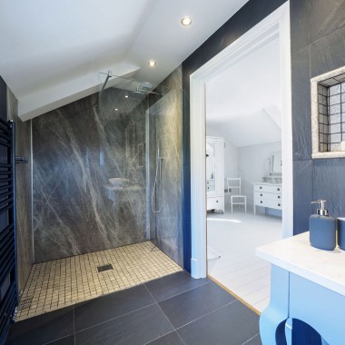 Picture of en-suite wet room with large radiator and slate floor and walls